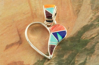  Stunning Heart Pendant featuring Genuine Kingman Turquoise, Blue Lapis and Spiny Oyster Shell inlaid between ribbons of Sterling Silver with Fire and Ice Lab Opal Accents. Free 18" Sterling Silver Chain with Purchase of Pendant. Designed by Navajo Artist Artist Calvin Begay. Signed by the artist. 